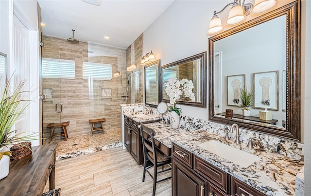 full bath with a sink, a shower stall, and double vanity