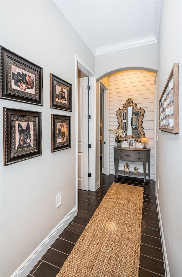 hallway with baseboards, dark wood-type flooring, and ornamental molding