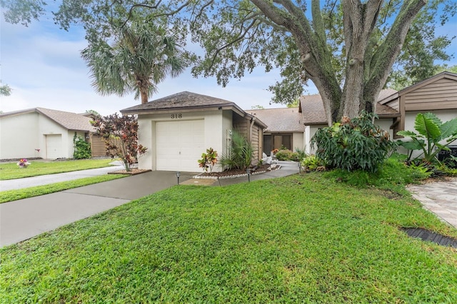 view of front of house featuring a garage, driveway, a front lawn, and stucco siding