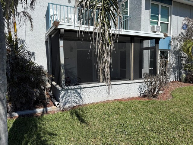 view of side of home with a yard, cooling unit, a sunroom, and stucco siding