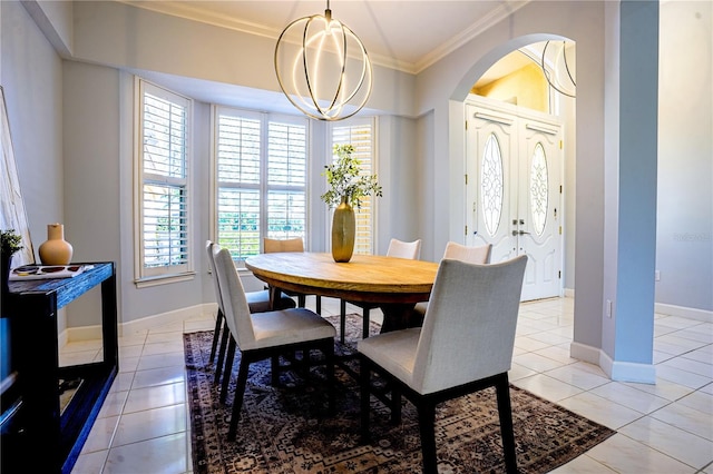 dining area featuring baseboards, ornamental molding, light tile patterned floors, arched walkways, and a notable chandelier