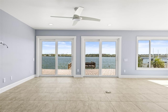 interior space with a wealth of natural light, baseboards, and a water view