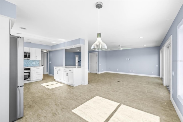 interior space with tasteful backsplash, white cabinetry, stainless steel appliances, and baseboards