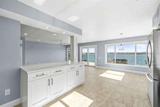 kitchen featuring baseboards, recessed lighting, a peninsula, freestanding refrigerator, and white cabinets