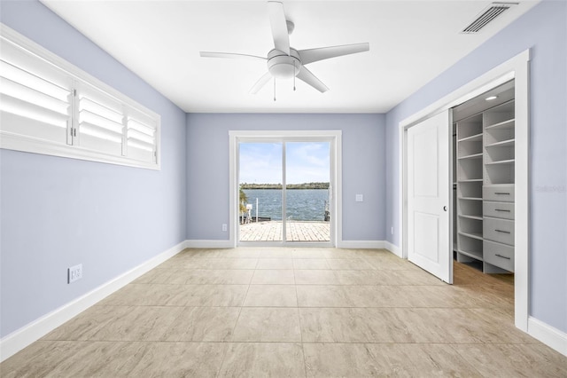 unfurnished bedroom featuring visible vents, baseboards, a water view, a closet, and access to outside