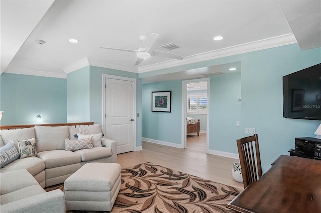 living room featuring a ceiling fan, light wood-style floors, visible vents, and ornamental molding