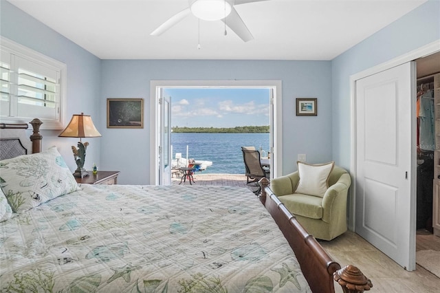 bedroom with a water view, ceiling fan, and access to outside