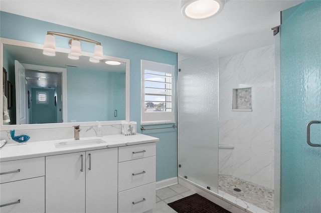 full bath featuring tile patterned floors, a marble finish shower, and vanity