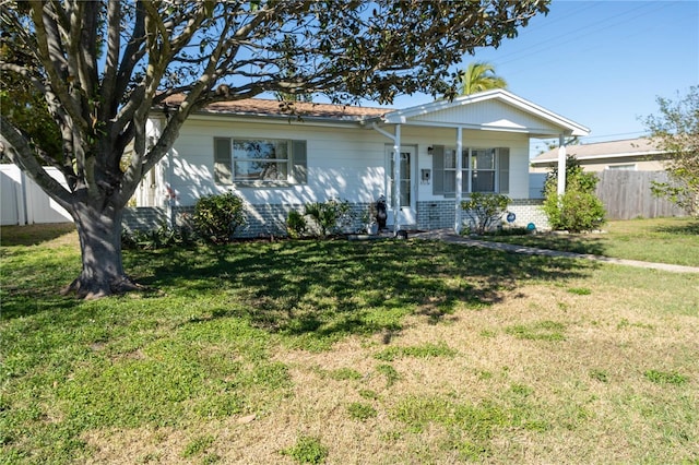 view of front of home with brick siding, a front yard, and fence