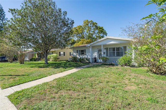 ranch-style home featuring a front lawn, covered porch, and brick siding