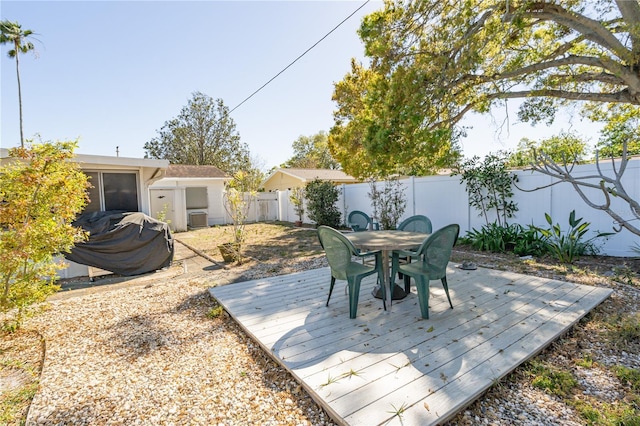 view of patio featuring cooling unit, outdoor dining area, a deck, and a fenced backyard