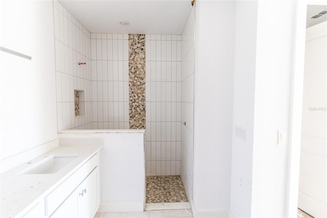 bathroom featuring visible vents, a walk in shower, and vanity