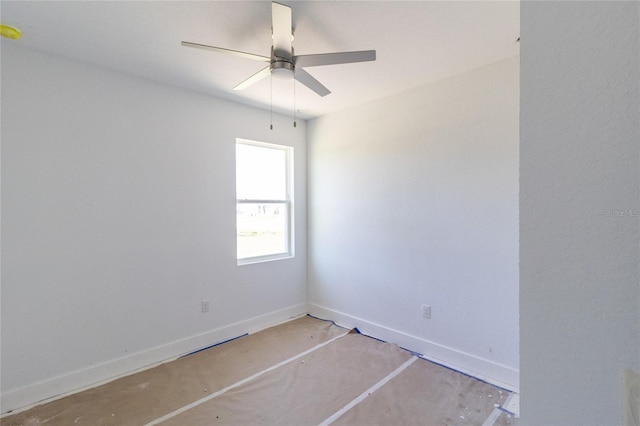 empty room with ceiling fan, concrete floors, and baseboards