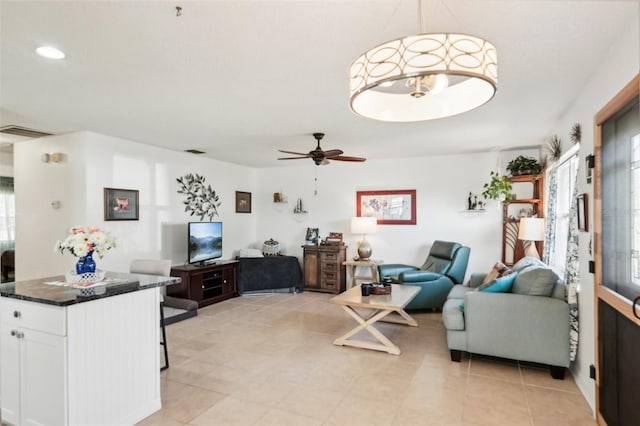 living room featuring a ceiling fan and visible vents