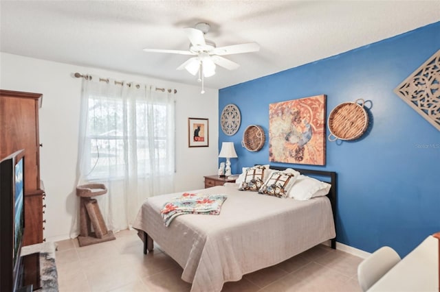 tiled bedroom featuring baseboards and ceiling fan