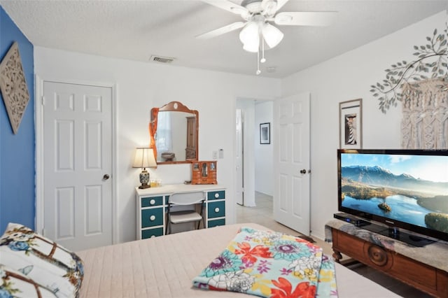 bedroom featuring visible vents, a textured ceiling, and ceiling fan