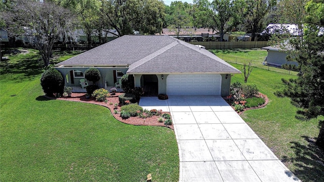 single story home with a front yard, fence, stucco siding, concrete driveway, and a garage