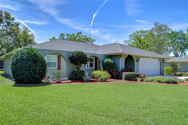 ranch-style home with a shingled roof, a front lawn, stucco siding, driveway, and an attached garage