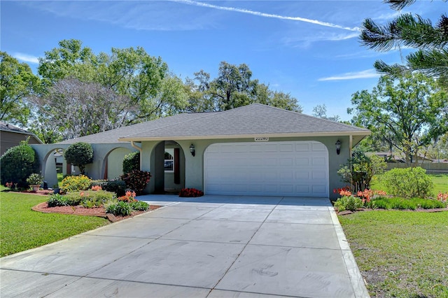 ranch-style house with stucco siding, an attached garage, driveway, and a front lawn