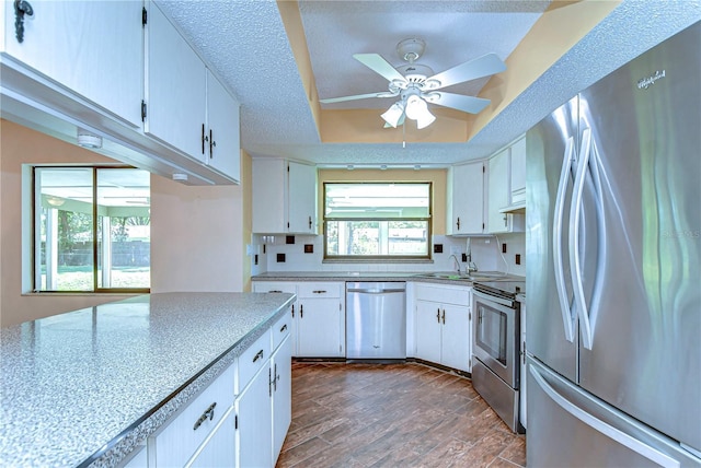 kitchen featuring a textured ceiling, white cabinets, a ceiling fan, and stainless steel appliances