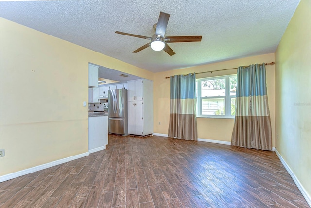 spare room with baseboards, a textured ceiling, ceiling fan, and dark wood-style flooring