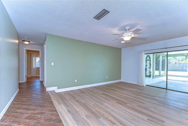 empty room with visible vents, baseboards, wood finished floors, and a ceiling fan