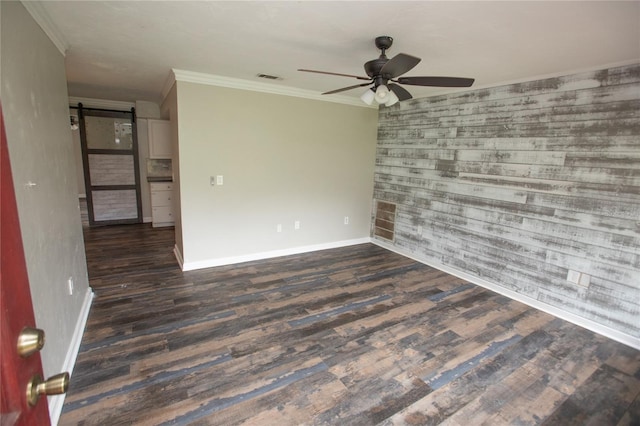 unfurnished room with baseboards, a barn door, wood finished floors, and a ceiling fan