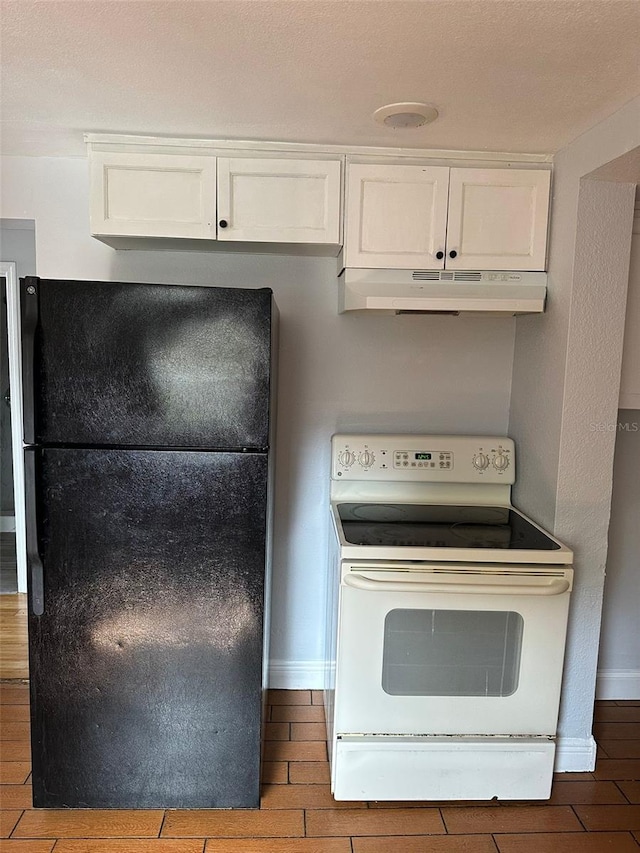 kitchen featuring white electric range, freestanding refrigerator, white cabinets, under cabinet range hood, and baseboards