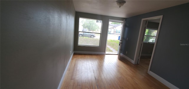 doorway to outside featuring baseboards and wood finished floors