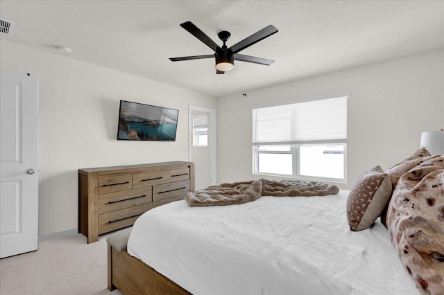 bedroom with a ceiling fan, light colored carpet, and visible vents