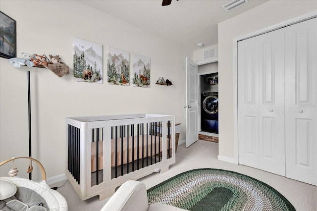 bedroom with washer / dryer, carpet flooring, visible vents, and a closet