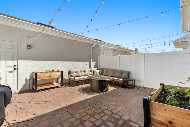 view of patio / terrace featuring a vegetable garden, fence private yard, and an outdoor hangout area