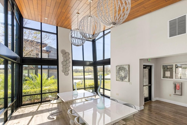 interior space featuring a wall of windows, wooden ceiling, visible vents, and a chandelier