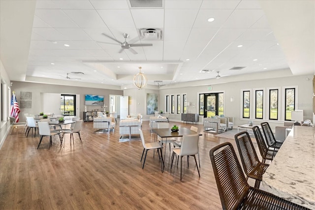 dining room featuring a raised ceiling, visible vents, a wealth of natural light, and ceiling fan