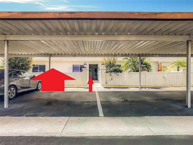 covered parking lot featuring fence