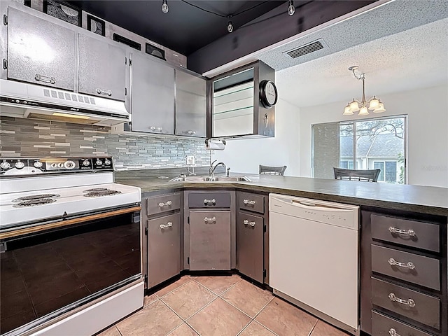 kitchen with dark countertops, visible vents, under cabinet range hood, white appliances, and a textured ceiling