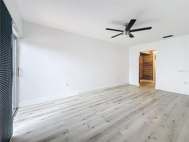 unfurnished bedroom featuring baseboards, visible vents, a textured ceiling, and light wood-style floors