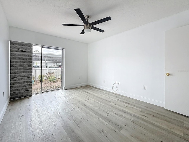 empty room featuring ceiling fan, wood finished floors, baseboards, and a textured ceiling