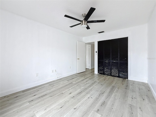 unfurnished bedroom with visible vents, ceiling fan, baseboards, wood finished floors, and a textured ceiling