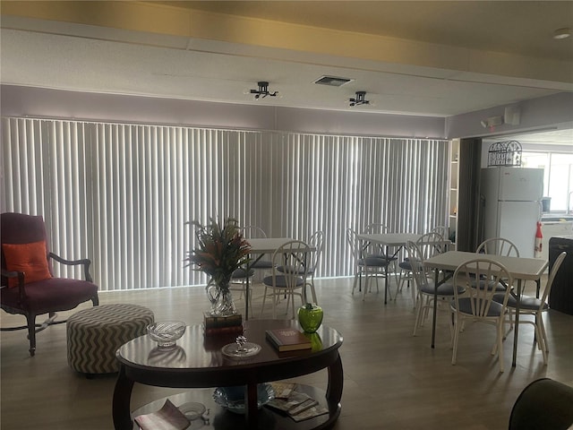 living room with beam ceiling, wood finished floors, and visible vents