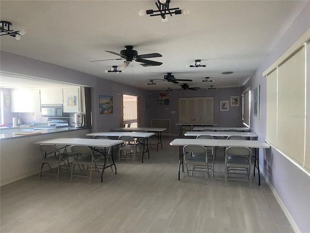 dining area featuring baseboards, a textured ceiling, and wood finished floors