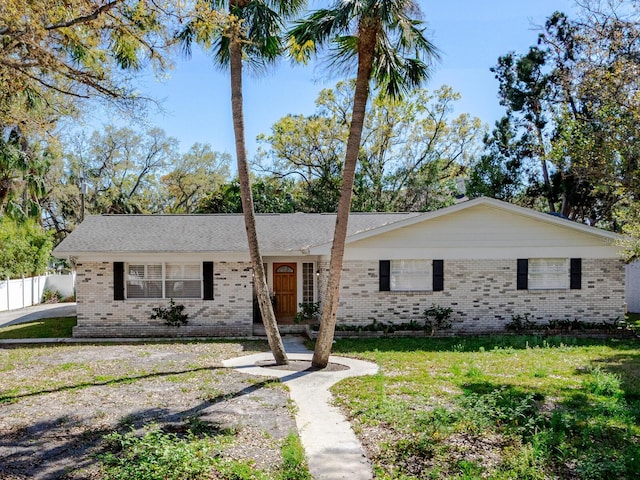 single story home with a front yard, fence, and brick siding