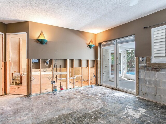 interior space with concrete block wall and a textured ceiling