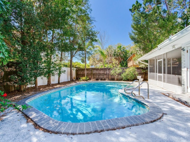 view of swimming pool with a fenced in pool, a patio, a fenced backyard, and a sunroom