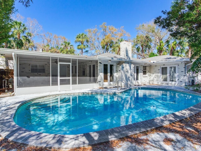 outdoor pool with french doors, a ceiling fan, a patio, and a sunroom