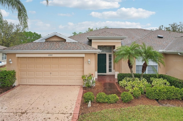 view of front of property with a shingled roof, a garage, driveway, and stucco siding