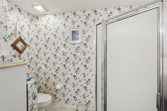 full bath featuring toilet, a stall shower, wallpapered walls, and vanity