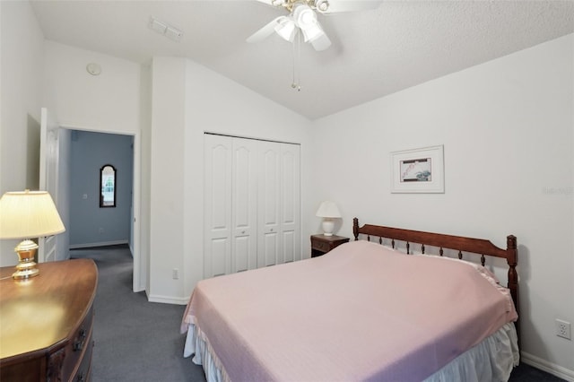 bedroom featuring a closet, vaulted ceiling, baseboards, and dark colored carpet