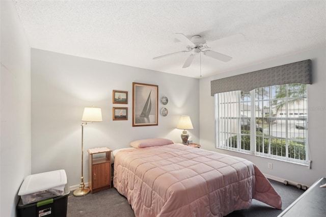 bedroom featuring carpet flooring, a textured ceiling, baseboards, and a ceiling fan