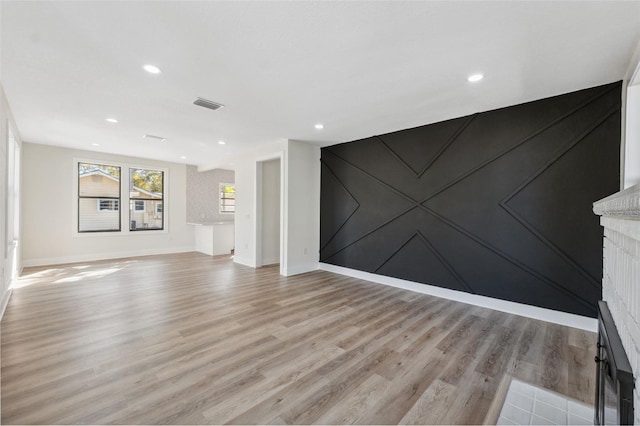 unfurnished living room featuring light wood finished floors, recessed lighting, visible vents, and baseboards